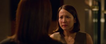 Movie still from “Parasite” (2019), directed by Bong Joon Ho – A woman looking at the camera while sitting in front of a mirror; Close Up shot, Over the shoulder angle
