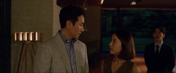 Movie still from “Parasite” (2019), directed by Bong Joon Ho – A man and a woman standing next to each other; Medium shot, Over the shoulder angle