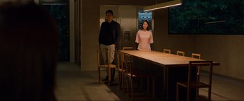 Movie still from “Parasite” (2019), directed by Bong Joon Ho – A man and a woman standing in front of a dining table; Wide shot, Over the shoulder angle