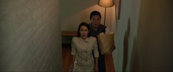Movie still from “Parasite” (2019), directed by Bong Joon Ho – A man and a woman are walking down a hallway; Medium shot, High angle