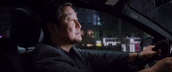 Movie still from “Parasite” (2019), directed by Bong Joon Ho – A man sitting in the driver's seat of a car at night; Close Up shot, Over the shoulder angle