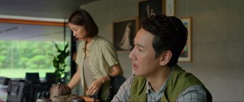 Movie still from “Parasite” (2019), directed by Bong Joon Ho – A man and a woman sitting at a table; Medium shot, Over the shoulder angle