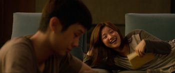 Movie still from “Parasite” (2019), directed by Bong Joon Ho – A young girl and a young boy are smiling; Close Up shot, Over the shoulder angle