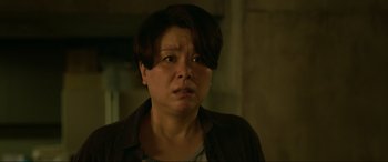 Movie still from “Parasite” (2019), directed by Bong Joon Ho – A woman with short brown hair is looking at the camera; Close Up shot, Over the shoulder angle