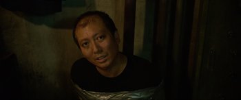 Movie still from “Parasite” (2019), directed by Bong Joon Ho – A man with a duct tape around his neck; Close Up shot, High angle
