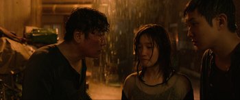 Movie still from “Parasite” (2019), directed by Bong Joon Ho – A man and a woman standing next to each other in the rain; Close Up shot, Over the shoulder angle