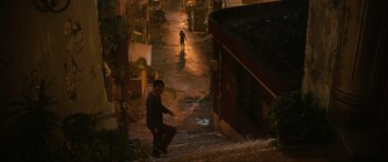Movie still from “Parasite” (2019), directed by Bong Joon Ho – A man riding a skate board down the side of a street; Extreme Wide shot, High angle