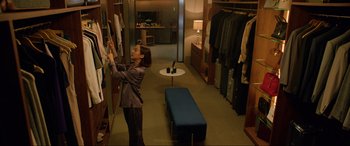 Movie still from “Parasite” (2019), directed by Bong Joon Ho – A woman is looking at clothes in a closet; Wide shot, High angle
