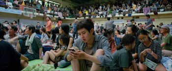 Movie still from “Parasite” (2019), directed by Bong Joon Ho – A group of young people sitting in a stadium; Medium shot, High angle