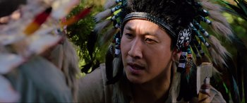 Movie still from “Parasite” (2019), directed by Bong Joon Ho – A person wearing a headdress; Close Up shot, Over the shoulder angle