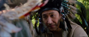 Movie still from “Parasite” (2019), directed by Bong Joon Ho – A person wearing a headdress; Close Up shot, Over the shoulder angle