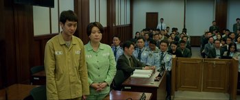 Movie still from “Parasite” (2019), directed by Bong Joon Ho – A group of people in a room with a table; Medium shot, Low angle