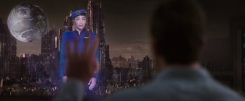 Movie still from “Passengers” (2016), directed by Morten Tyldum – A man is watching a video of a woman in a uniform; Medium shot, Over the shoulder angle