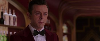 Movie still from “Passengers” (2016), directed by Morten Tyldum – A person wearing a suit and bow tie; Close Up shot, Over the shoulder angle