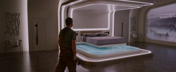 Movie still from “Passengers” (2016), directed by Morten Tyldum – A man standing next to a bed in a room; Wide shot, High angle
