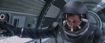 Movie still from “Passengers” (2016), directed by Morten Tyldum – A man in a spacesuit with a helmet on; Medium shot, Over the shoulder angle