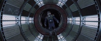 Movie still from “Passengers” (2016), directed by Morten Tyldum – A man in a spacesuit is inside of a space station; Wide shot, Overhead angle