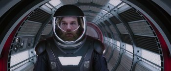 Movie still from “Passengers” (2016), directed by Morten Tyldum – A man in a spacesuit and helmet in a tunnel; Close Up shot, Overhead angle