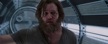 Movie still from “Passengers” (2016), directed by Morten Tyldum – A man with a long beard is looking at the camera; Close Up shot, Low angle