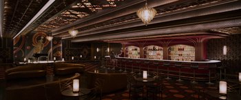 Movie still from “Passengers” (2016), directed by Morten Tyldum – A bar with a lot of tables and chairs in it; Extreme Wide shot, High angle