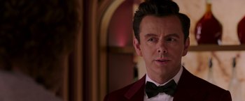 Movie still from “Passengers” (2016), directed by Morten Tyldum – A person wearing a suit and bow tie; Close Up shot, Over the shoulder angle