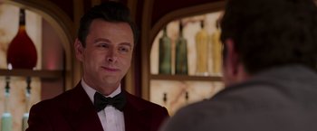 Movie still from “Passengers” (2016), directed by Morten Tyldum – A person wearing a suit and bow tie; Close Up shot, Over the shoulder angle