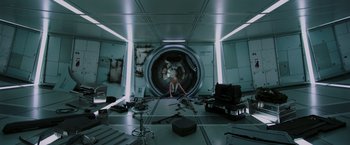 Movie still from “Passengers” (2016), directed by Morten Tyldum – A person sitting in a room with a large hole in the floor; Wide shot, Overhead angle