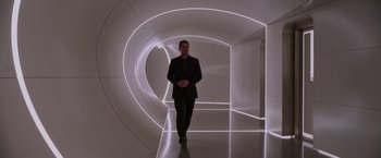 Movie still from “Passengers” (2016), directed by Morten Tyldum – A man in a suit and tie walking in an illuminated tunnel; Wide shot, Low angle