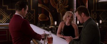 Movie still from “Passengers” (2016), directed by Morten Tyldum – A woman sitting at a bar next to a man; Medium shot, Over the shoulder angle