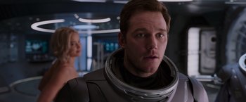 Movie still from “Passengers” (2016), directed by Morten Tyldum – A person wearing a space suit; Close Up shot, Over the shoulder angle