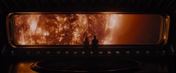 Movie still from “Passengers” (2016), directed by Morten Tyldum – Two people are sitting in front of a large screen; Extreme Wide shot, High angle