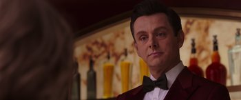 Movie still from “Passengers” (2016), directed by Morten Tyldum – A person wearing a suit and bow tie; Close Up shot, Over the shoulder angle