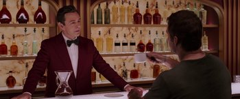 Movie still from “Passengers” (2016), directed by Morten Tyldum – A man standing at a bar with a drink in his hand; Medium shot, Over the shoulder angle