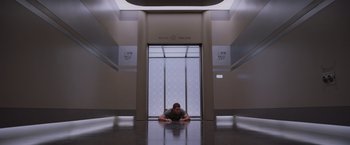 Movie still from “Passengers” (2016), directed by Morten Tyldum – A man laying on the ground in front of an elevator; Wide shot, Overhead angle