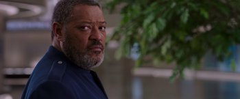 Movie still from “Passengers” (2016), directed by Morten Tyldum – An older man with a beard looking at the camera; Close Up shot, Over the shoulder angle