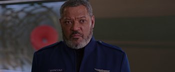 Movie still from “Passengers” (2016), directed by Morten Tyldum – An older man with a beard wearing a blue jacket; Close Up shot, Over the shoulder angle