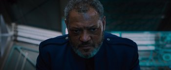 Movie still from “Passengers” (2016), directed by Morten Tyldum – A man with a beard and a blue jacket on; Close Up shot, Low angle