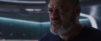 Movie still from “Passengers” (2016), directed by Morten Tyldum – An older man with a beard looking at the camera; Close Up shot, Low angle