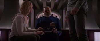 Movie still from “Passengers” (2016), directed by Morten Tyldum – A man in a blue jacket is holding a book; Medium shot, Over the shoulder angle