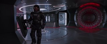 Movie still from “Passengers” (2016), directed by Morten Tyldum – A man in a spacesuit standing in a room; Wide shot, High angle