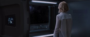 Movie still from “Passengers” (2016), directed by Morten Tyldum – A woman looking out of a window at the night sky; Wide shot, Over the shoulder angle