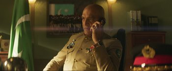 Movie still from “Pathaan” (2023), directed by Siddharth Anand – A man in a military uniform talking on a cell phone; Medium shot, Low angle