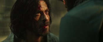 Movie still from “Pathaan” (2023), directed by Siddharth Anand – A person with blood all over his face; Close Up shot, Over the shoulder angle