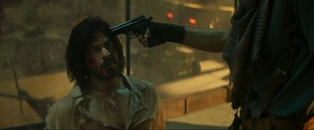 Movie still from “Pathaan” (2023), directed by Siddharth Anand – A man is holding a gun up to his head; Close Up shot, Over the shoulder angle