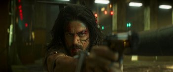 Movie still from “Pathaan” (2023), directed by Siddharth Anand – A person holding a gun in a room; Close Up shot, Low angle