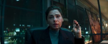 Movie still from “Pathaan” (2023), directed by Siddharth Anand – A woman sitting in an office chair holding a cigarette in her hand; Close Up shot, Low angle