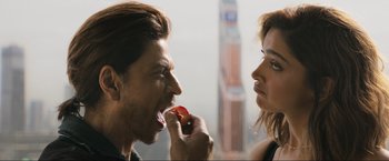 Movie still from “Pathaan” (2023), directed by Siddharth Anand – A man and a woman are eating an apple together; Close Up shot, Over the shoulder angle