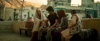 Movie still from “Pathaan” (2023), directed by Siddharth Anand – A man sitting next to a woman and another woman; Wide shot, Low angle