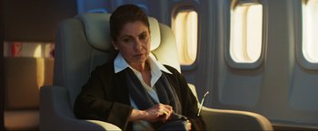 Movie still from “Pathaan” (2023), directed by Siddharth Anand – A woman sitting in a chair on an airplane; Medium shot, High angle