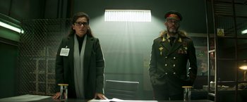 Movie still from “Pathaan” (2023), directed by Siddharth Anand – A man and a woman standing in front of a table; Medium shot, Low angle